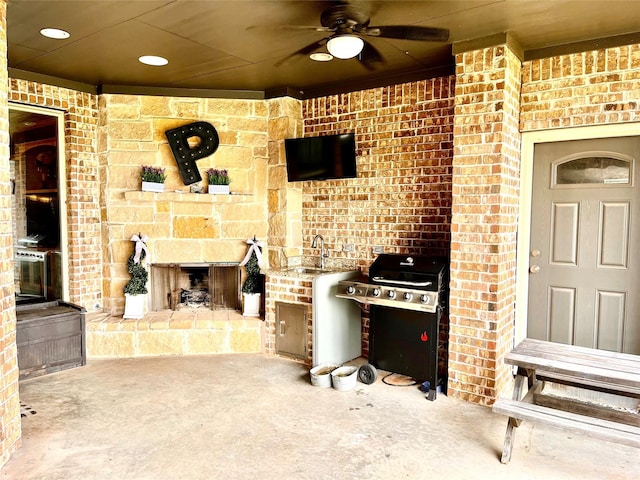 view of patio / terrace featuring ceiling fan, area for grilling, sink, and an outdoor stone fireplace