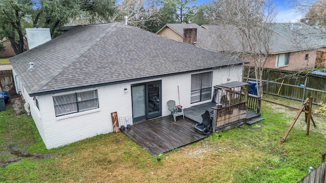 rear view of property with a yard and a deck