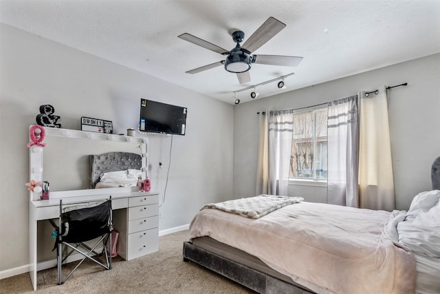 carpeted bedroom with ceiling fan, rail lighting, and a textured ceiling