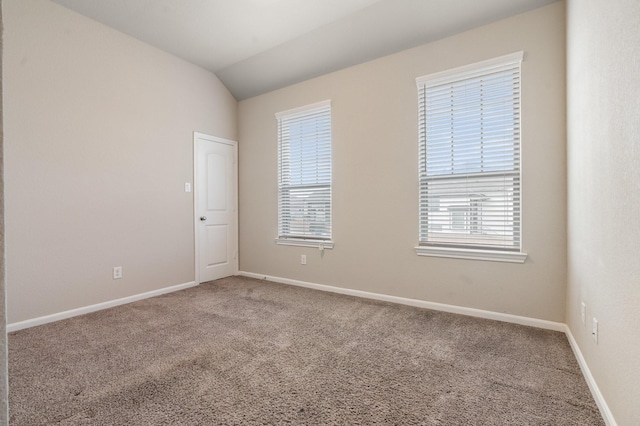 unfurnished room featuring lofted ceiling, carpet floors, and a wealth of natural light