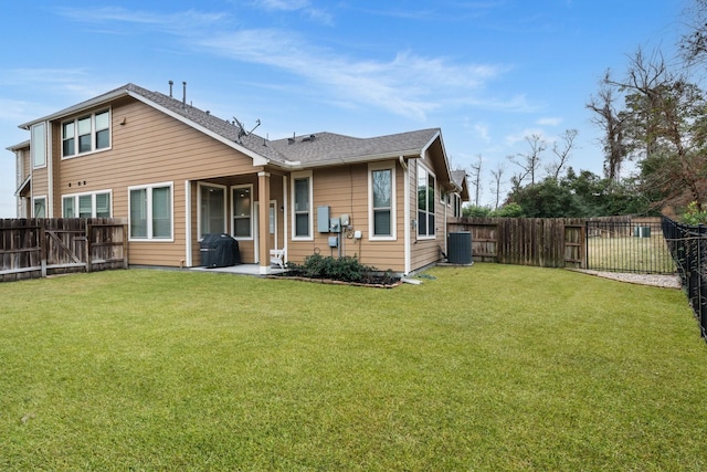 rear view of house with cooling unit and a yard