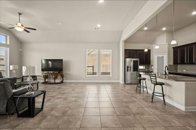 living room featuring sink, light tile patterned floors, high vaulted ceiling, and ceiling fan