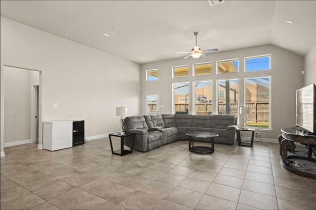 tiled living room featuring ceiling fan and high vaulted ceiling