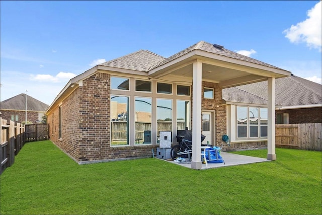 rear view of property with a yard and a patio