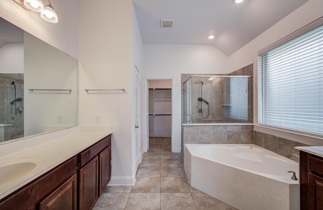 full bath with a walk in closet, a garden tub, visible vents, a stall shower, and vanity