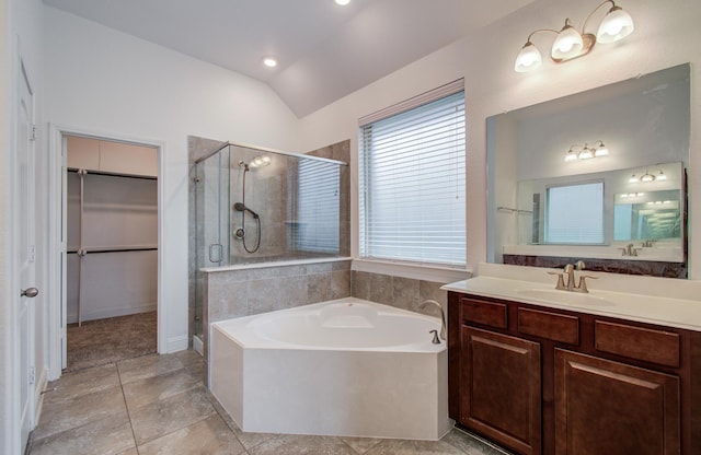 bathroom with a walk in closet, vanity, a shower stall, lofted ceiling, and a garden tub