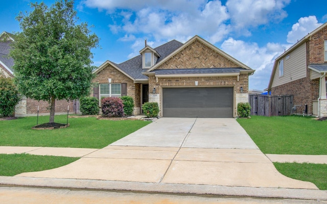 view of front facade featuring brick siding, an attached garage, driveway, and a front yard
