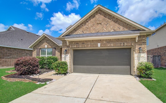 view of front of property with brick siding, driveway, a front yard, and a garage