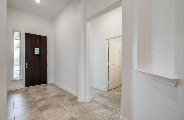 entryway featuring baseboards and light tile patterned flooring