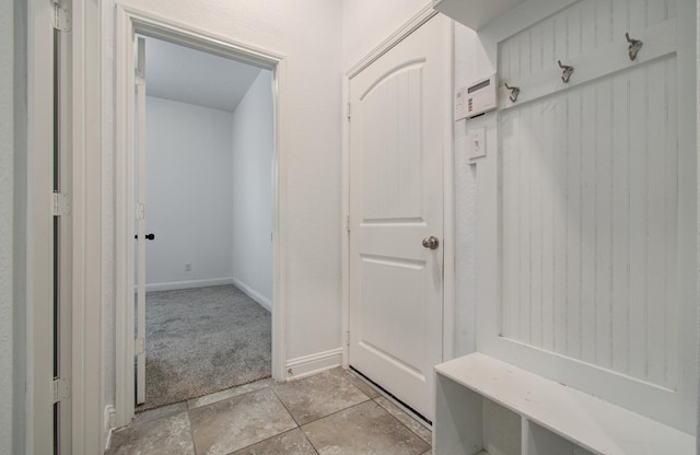 mudroom with baseboards and light colored carpet