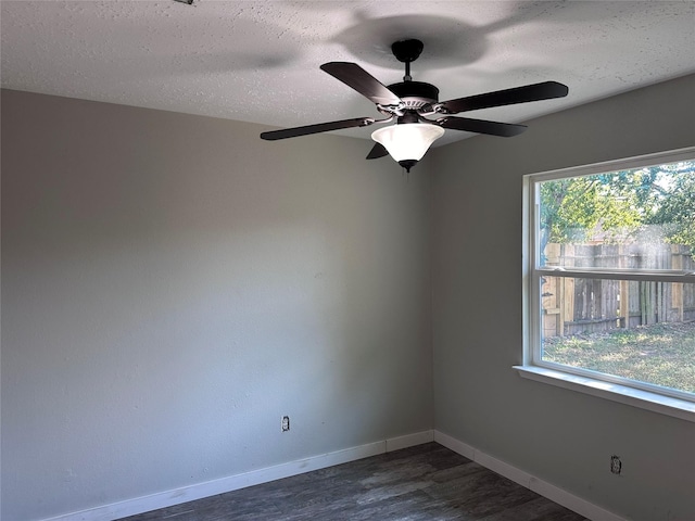 unfurnished room featuring dark wood-type flooring, a wealth of natural light, and a textured ceiling