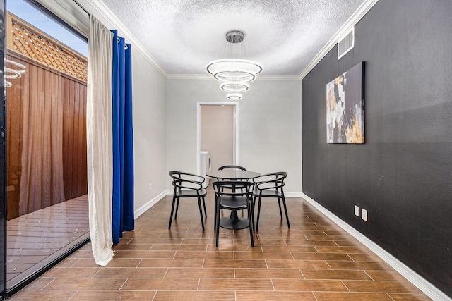 dining space with an inviting chandelier, crown molding, and a textured ceiling