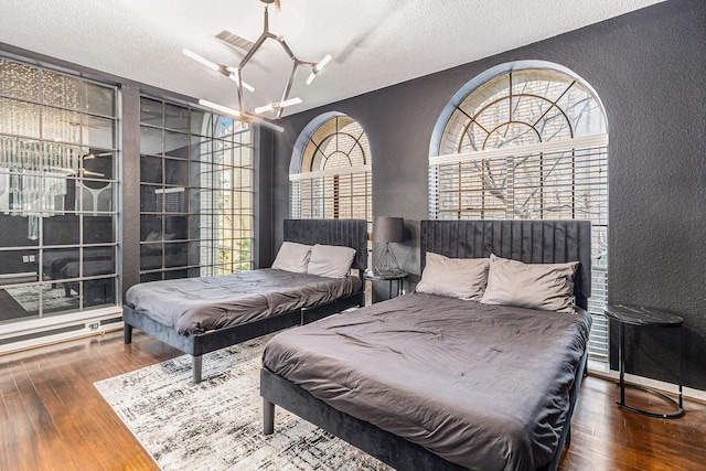 bedroom featuring wood-type flooring and a textured ceiling