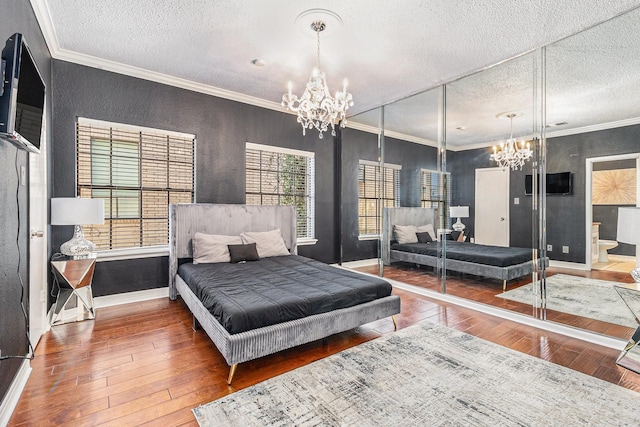 bedroom featuring an inviting chandelier, crown molding, and hardwood / wood-style flooring