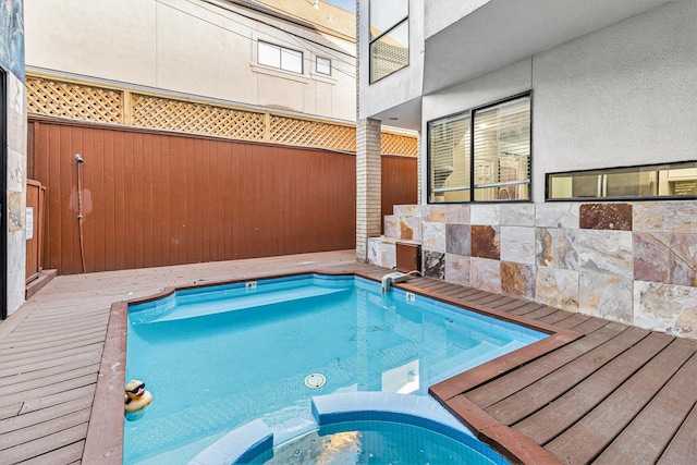 view of swimming pool with an in ground hot tub and a deck