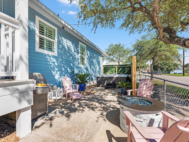 view of patio with a jacuzzi and a fire pit