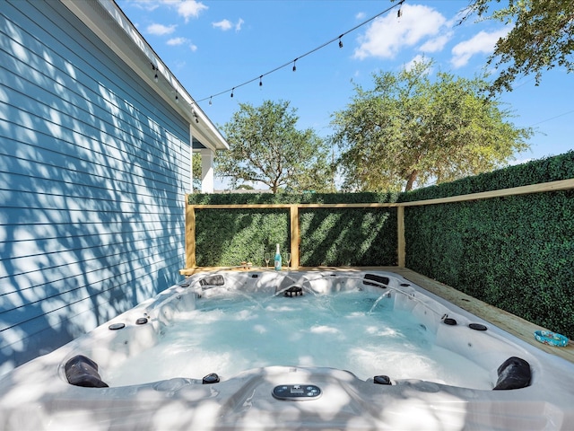 view of swimming pool featuring a hot tub