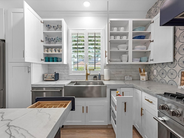 kitchen featuring white cabinetry, light stone counters, and tasteful backsplash