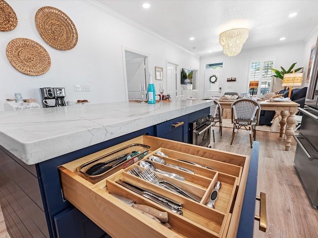 kitchen featuring ornamental molding, blue cabinets, and light hardwood / wood-style floors