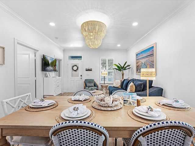 dining room with ornamental molding, light hardwood / wood-style floors, and a notable chandelier