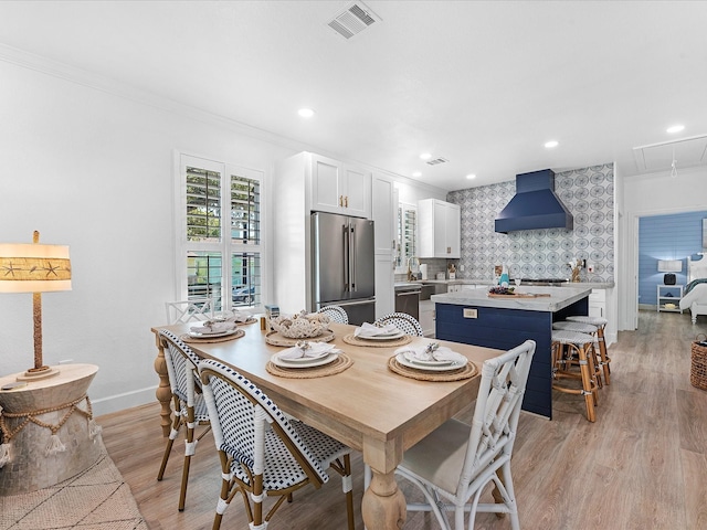 dining area featuring crown molding and light hardwood / wood-style floors