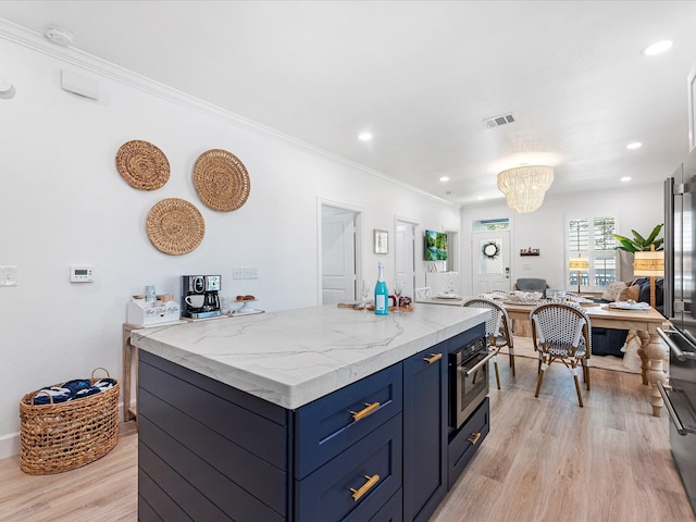 kitchen featuring blue cabinets, crown molding, a kitchen island, oven, and light hardwood / wood-style floors