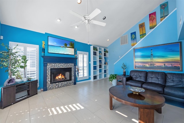 living room featuring ceiling fan, high vaulted ceiling, light tile patterned floors, and a fireplace