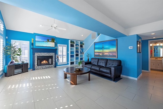 living room featuring plenty of natural light, a tiled fireplace, tile patterned flooring, and built in features