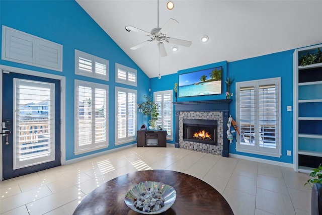 tiled living room featuring ceiling fan, high vaulted ceiling, and a fireplace