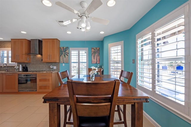 dining space featuring ceiling fan, a healthy amount of sunlight, and sink