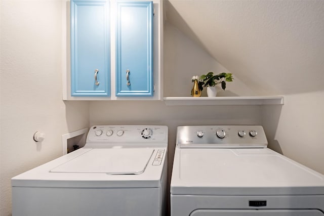 clothes washing area featuring cabinets and washer and dryer