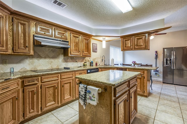 kitchen with a kitchen island, sink, light tile patterned floors, black appliances, and a textured ceiling