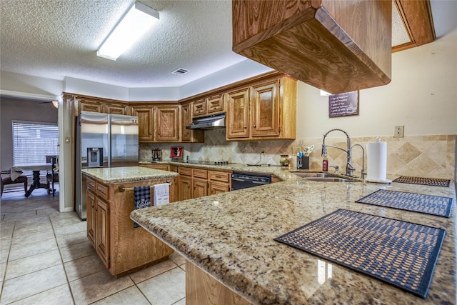 kitchen with light stone counters, sink, kitchen peninsula, and dishwasher