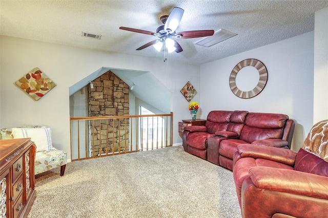 living room featuring ceiling fan, carpet flooring, and a textured ceiling