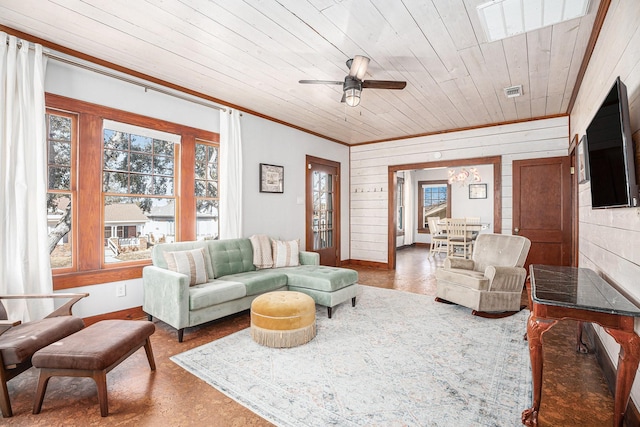 living room with wood ceiling, ornamental molding, ceiling fan, and wood walls