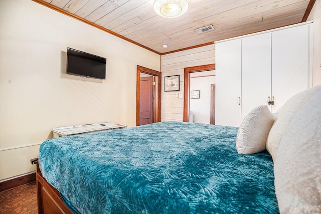 bedroom with crown molding, wood ceiling, and wood walls