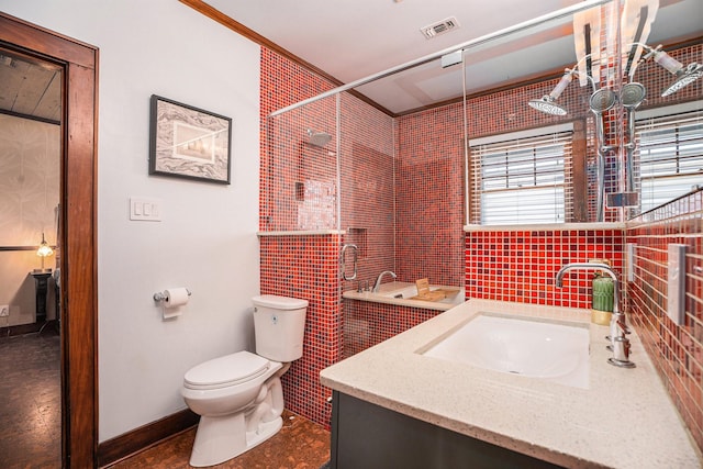 bathroom featuring vanity, a tile shower, decorative backsplash, and toilet