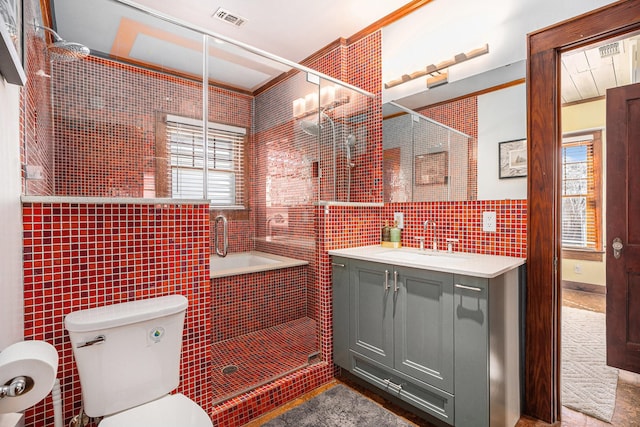 bathroom featuring tile walls, vanity, a shower with door, and a healthy amount of sunlight