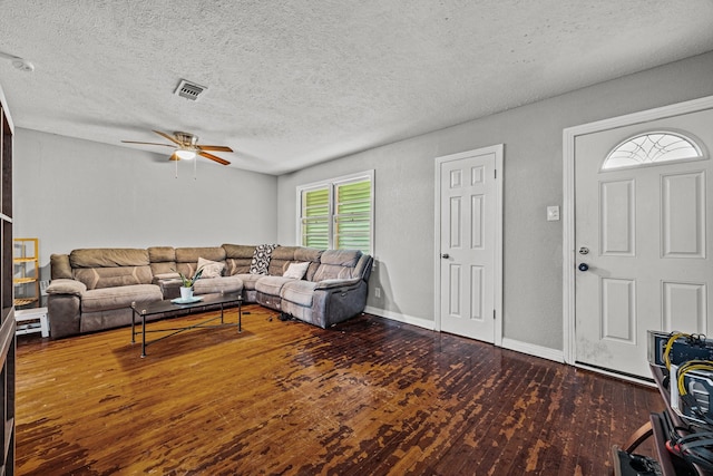 living room featuring ceiling fan, a textured ceiling, and dark hardwood / wood-style flooring