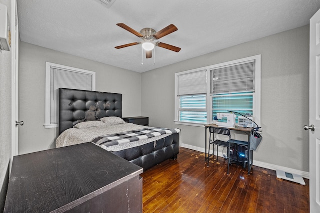 bedroom with dark wood-type flooring, ceiling fan, and a textured ceiling