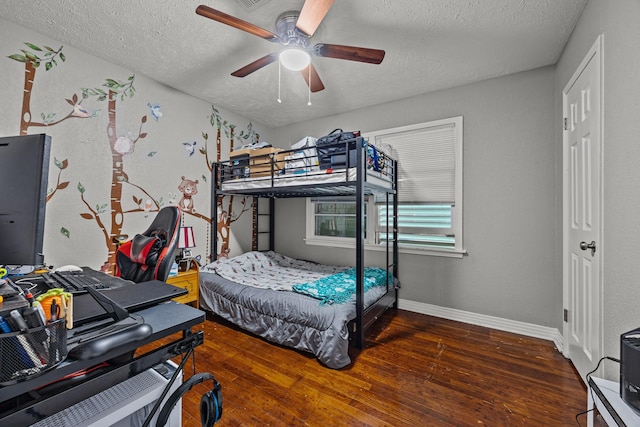 bedroom with ceiling fan, dark hardwood / wood-style floors, and a textured ceiling