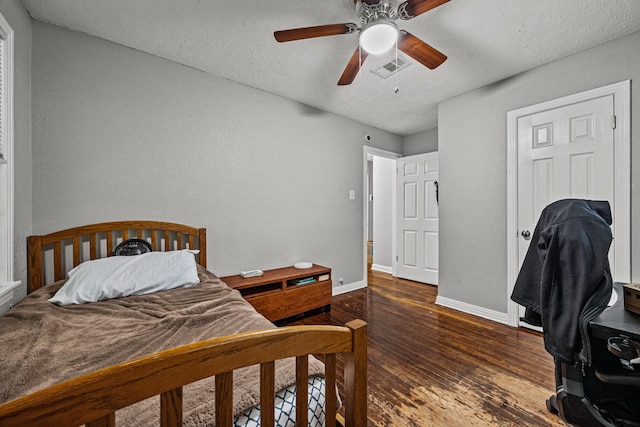 bedroom with ceiling fan, dark hardwood / wood-style floors, and a textured ceiling