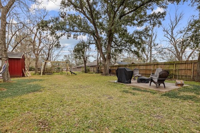 view of yard featuring a fire pit, a patio area, and a playground