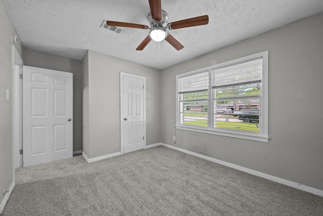 2817 John St, La Marque, TX 77568 - unfurnished bedroom with carpet floors, a textured ceiling, a ceiling fan, baseboards, and visible vents