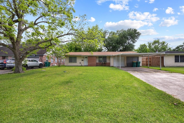 2817 John St, La Marque, TX 77568 - ranch-style house featuring fence, brick siding, a front yard, a carport, and driveway