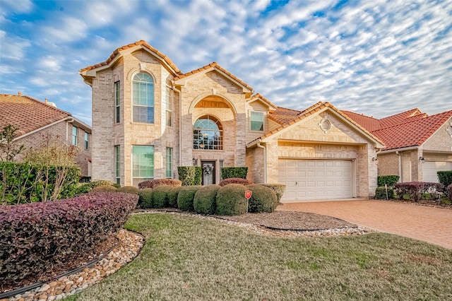 mediterranean / spanish-style home featuring a garage and a front yard