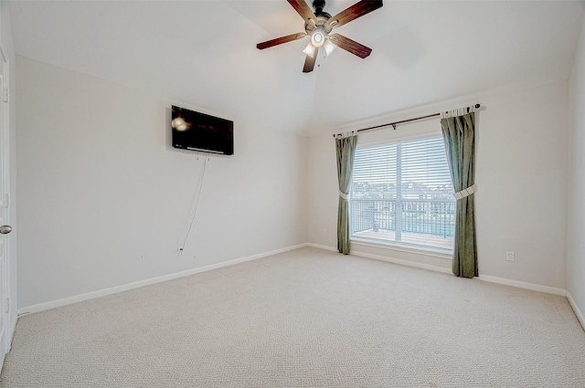 empty room with vaulted ceiling, light colored carpet, and ceiling fan