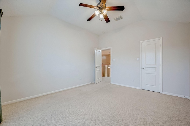 unfurnished bedroom featuring light colored carpet, ceiling fan, vaulted ceiling, and a closet