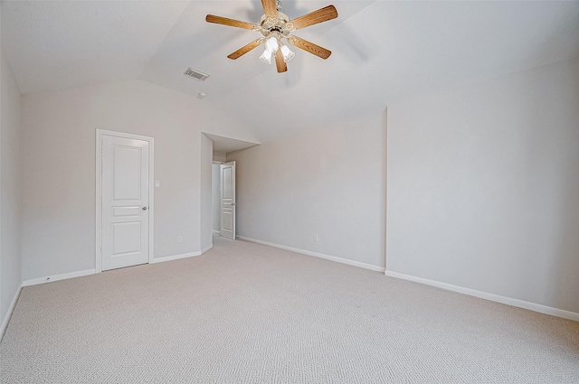 empty room featuring vaulted ceiling, carpet floors, and ceiling fan