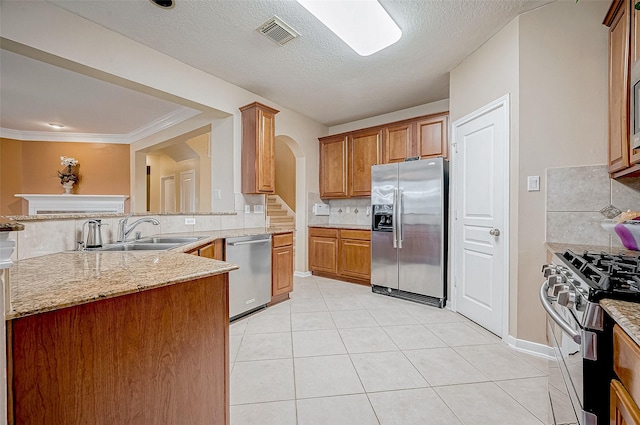 kitchen with sink, stainless steel appliances, light tile patterned flooring, decorative backsplash, and kitchen peninsula